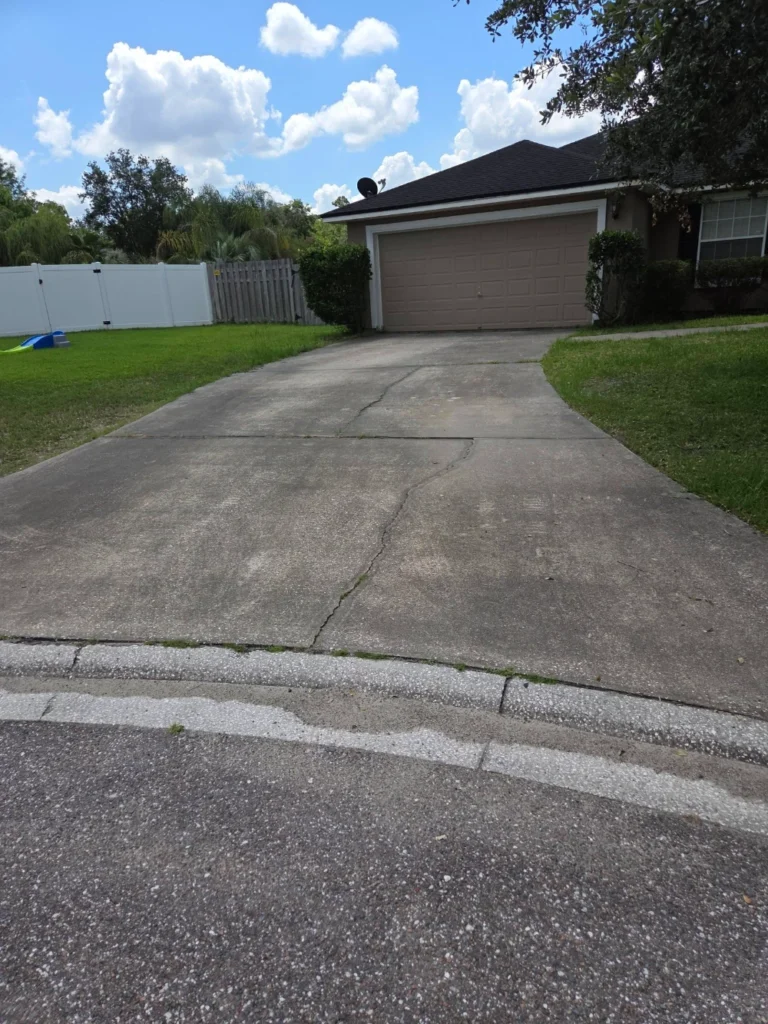 Driveway cleaning with white vinyl privacy fence in Jacksonville, FL